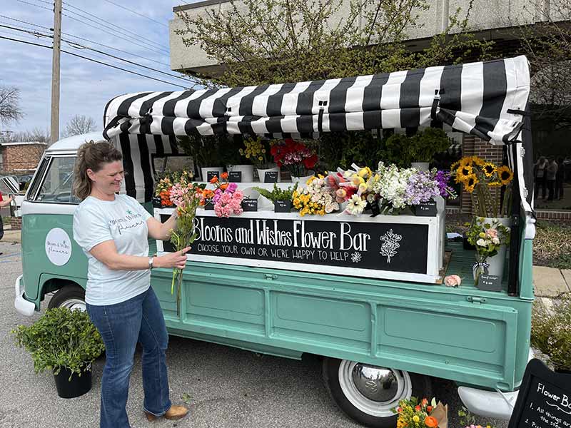 Stephanie standing in front of Sallie-The Blooms and Wishes flower truck
